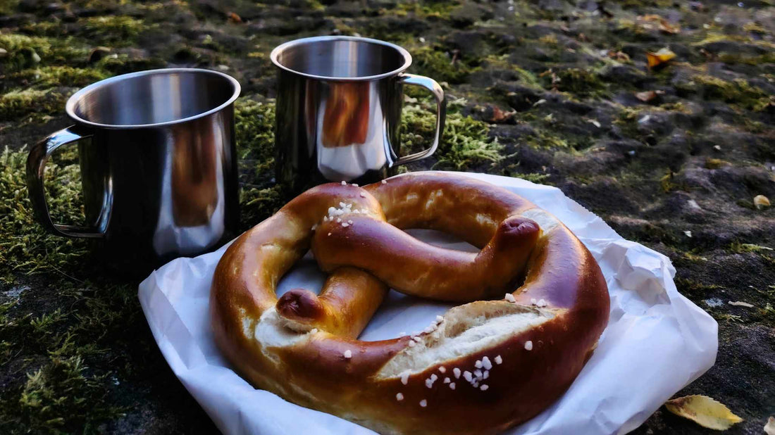 jardin de sorcières à Bergheim en Alsace, macro sur deux tasses de camping en inox avec du thé noix et un bretzel fait maison devant une maison traditionnelle alsacienne, Alsace, Haut-Rhin, Bergheim